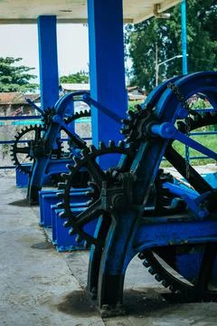 Blue machines with black gears on a station in a rural village on a sunny day Stock Photos
