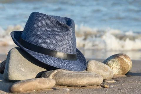 Blue man's hat on a stone on a background of sea waves. close-up Stock Photos