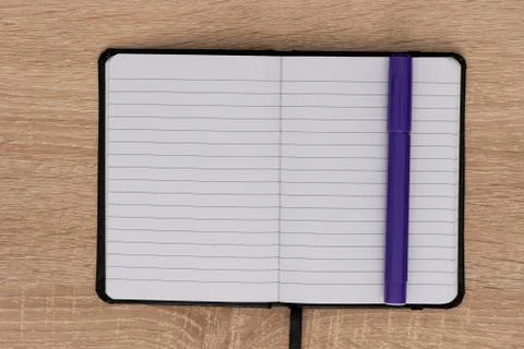 Blue marker and open notepad on desk Stock Photos