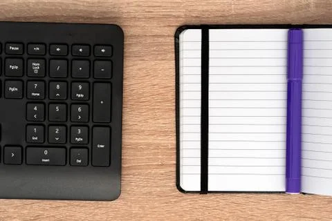 Blue marker on open notepad and keyboard Stock Photos