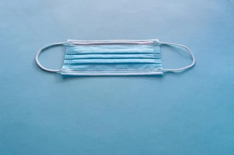 Blue medical face mask to avoid contagious diseases pattern on blue backgroun Foto stock