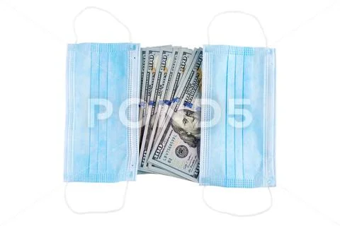 Blue medical face masks and stack of 100 USD banknotes. Isolated on white. Stock Photos