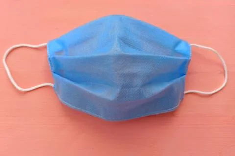 Blue medical mask with white elastic bands for the ears. Stock Photos