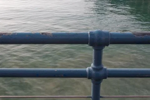 Blue metal railing with multiple layers of paint Stock Photos