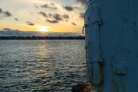 Blue metal structure at sunset over rippled sea Fotos de archivo