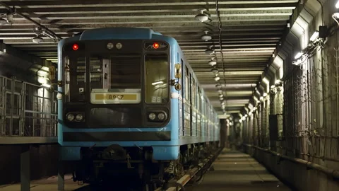 Blue metro train approaching in an illuminated underground tunnel, viewed head Видео 333050897