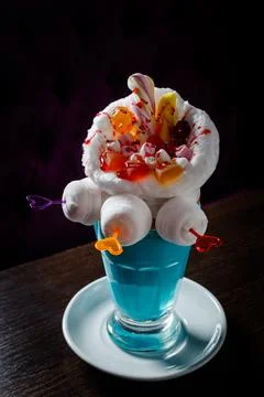Blue milkshake with donuts stands on the table in the cafe on dark background Stock Photos