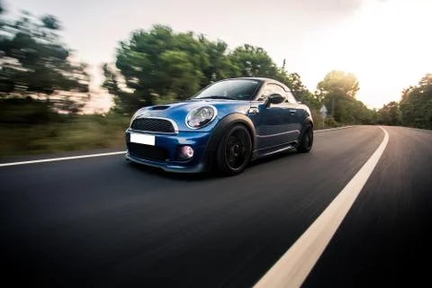 Blue mini cabriolet driving on the highway Stock Photos