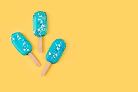 Blue mint ice cream popsicles on yellow background. Tasty and refreshing ice  Stock Photos