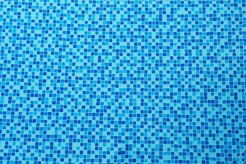 Blue mosaic tile texture pattern submerged in clean water inside a swimming.. Stock Photos