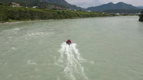 A blue motorboat is moving down the river. Passengers in red vests move in water Stock Footage 166087119