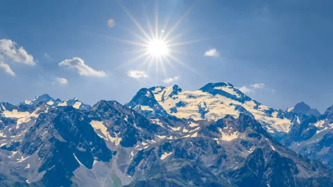 Blue mountain chain in snow under a sparke sun time lapse scene Stock Footage 239743570