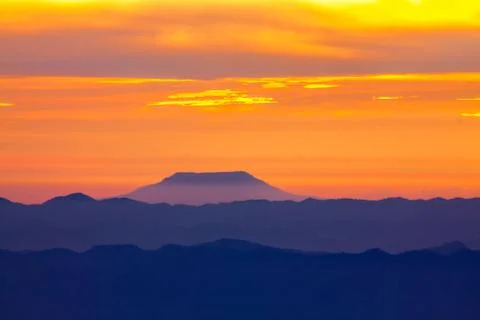 Blue mountain with orange sky while rising sun Foto stock