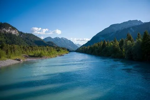 Blue Mountain River Flowing Through Forested Valley With Snow-Capped Peaks .. Stock Photos