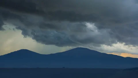 Blue mountain silhouette under a dense cloudy sky Stock Footage 150680869