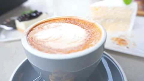 A blue mug of Frothy drink on the table at coffee shop. Stock-Footage 334648773