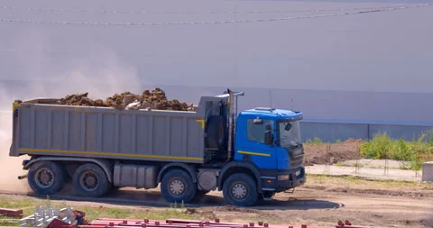 Blue multi-axle truck loaded with earth is drives to unload  Stock Footage 147634957