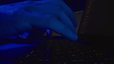 Blue Neon Closeup Dolly Slider Shot of Hand Typing on Laptop Keyboard With Progr Stock Footage 334948896