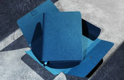 Blue notebook on dark textured background. Space for text. Stock Photos
