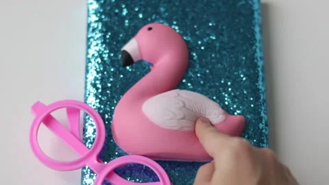 Blue notebook with glitter and soft toy pink flamindo on desk Stock-Footage 231978469