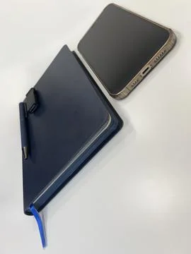 A blue notebook, a pen, a USB flash card, and a smartphone Stock Photos