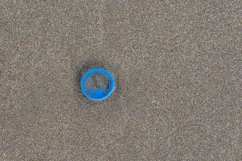 A blue object is sitting on a sandy beach Stock-Fotos