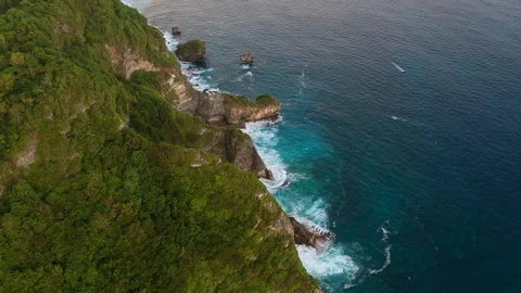 Blue ocean and cliffs covered with trees and grass. Bali shores from above. Aeri Stock Footage 109796759