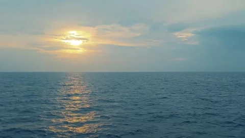 Blue ocean with sun rays coming through the clouds during sunrise or sunset.. Stock-Footage 275568170
