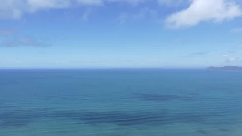 Blue ocean view from above, slow moving waves and clouds flowing by Stock Footage 81183529