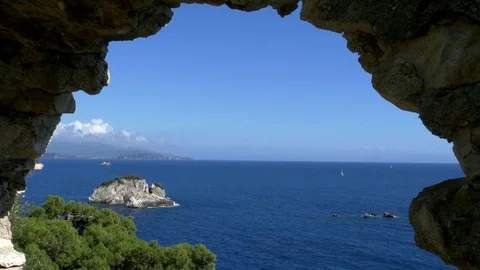 Blue ocean view seen through the arch of an ancient ruin located on a high cl Stock Footage 78219743