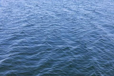 Blue ocean water surface texture with gentle ripples and natural wave pattern Stock Photos