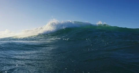 Blue ocean wave breaking at sunset Stock Footage 76261718