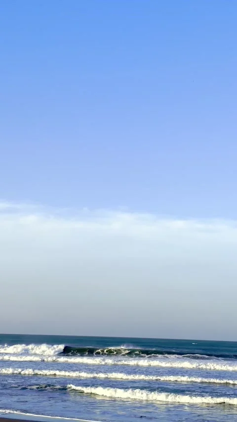 Blue ocean waves beneath clear coastal sky Stock Footage 335431446