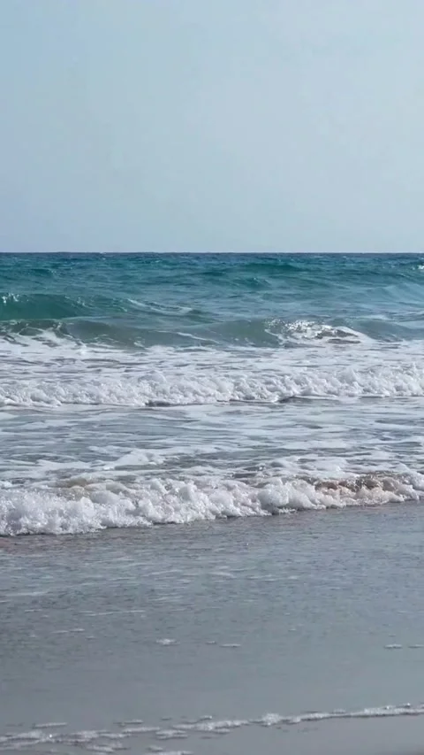 Blue ocean waves crashing on the sandy beach shore Stock Footage 334184820