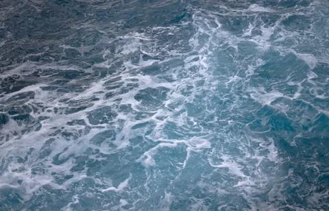 Blue ocean waves creating white foam seen from above. Foto stock