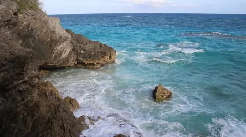 Blue ocean waves gently crashing on rocky Bermuda coast Stock Footage 12423199