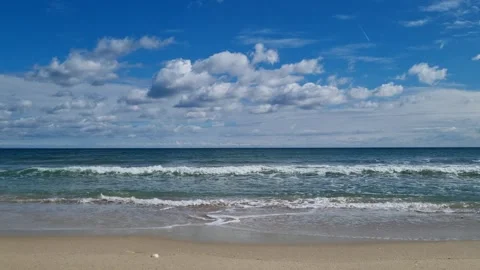 Blue Ocean Waves Rolling on Sandy Shore under Cloudy Sky 4K Stock Footage 319008896