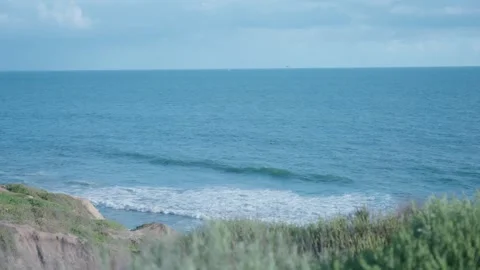 Blue Ocean Waves Rolling Toward a Grassy Bluff on the Coast Stock Footage 332628442