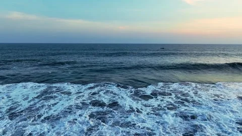 Blue ocean waves rolling toward dark shore Stock-Footage 335440429