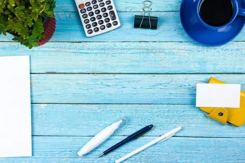 Blue Office desk table with computer, pen and a cup of coffee, lot of thing.. Stock Photos
