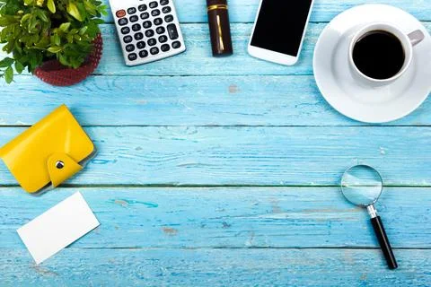 Blue office desk table with computer, pen and a cup of coffee, lot of thing.. Stock Photos