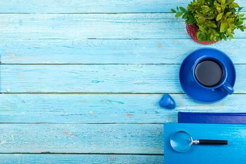 Blue office desk table with computer, pen and a cup of coffee, lot of things. Stock Photos