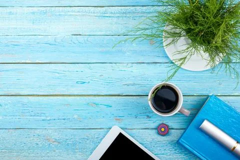 Blue office desk table with computer, pen and a cup of coffee, lot of thing.. Stock Photos