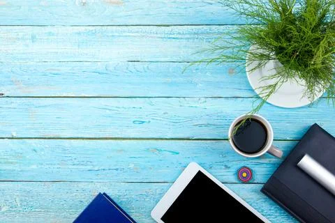 Blue office desk table with computer, pen and a cup of coffee, lot of thing.. Stock Photos