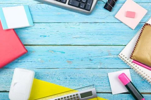 Blue office desk table with computer, pen and a cup of coffee, lot of things. Stock Photos