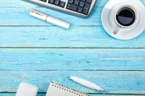 Blue office desk table with computer, pen and a cup of coffee, lot of thing.. Stock Photos