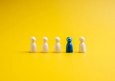The blue one with robot face, different standing out of the group of white .. Stock Photos