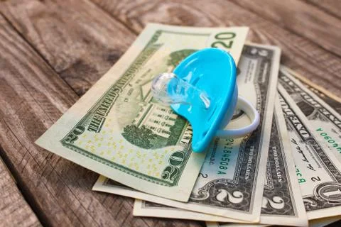 Blue pacifier on the background of money. Stock Photos