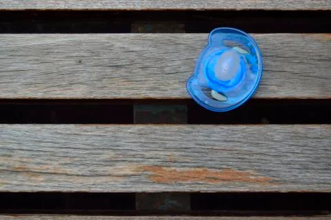 Blue pacifier on a bench Stock Photos