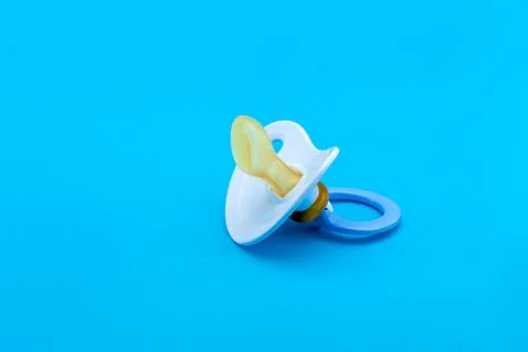 Blue pacifier made of soft silicone  isolated on blue background side view. Stock Photos